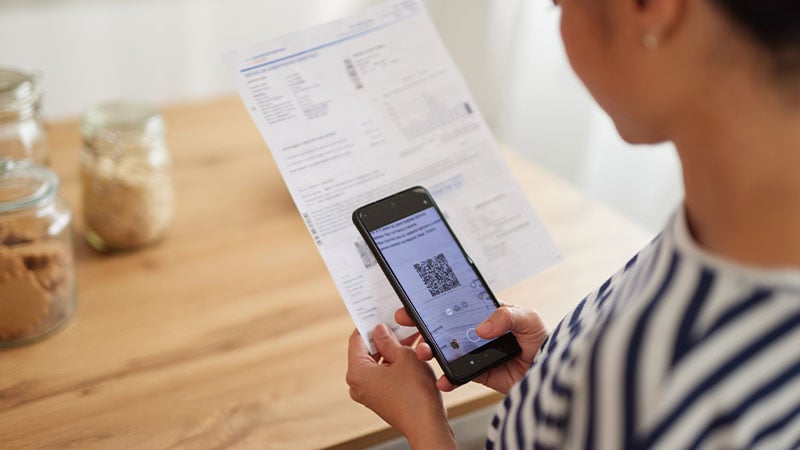 Frau scannt Dokument mit Smartphone